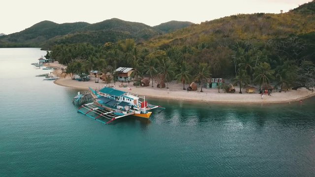 flying away from a bangka boat docked on the beach
