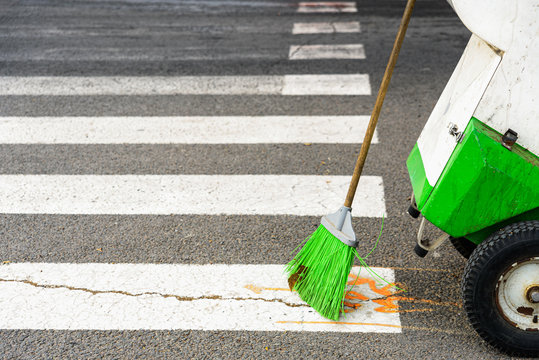 Broom of a street sweeper public employee keeps the city clean.