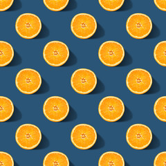 Seamless pattern of orange sliced on classic blue color background. Minimal, flat lay.