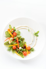 micro-greens and vegetables salad on a white plate