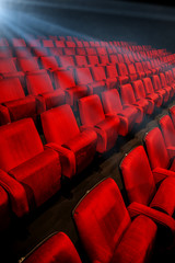 Movie theater empty auditorium with red seats and blue lighting