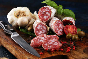 thinly sliced salami on a wooden texture on the background.