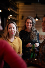 Group of friends standing in bar, drinking beer, chatting and having good time. Nightlife.