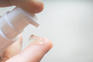 woman hands applying moisturizing cream to her finger skin from a tube. beautiful girl dropping collagen moisturizer serum into her hand at home