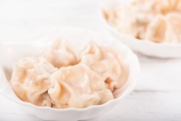 Fresh, delicious boiled pork gyoza dumplings, jiaozi on white background with soy sauce and chopsticks, close up, lifestyle. Homemade design concept.
