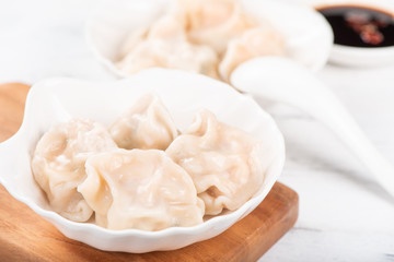 Obraz na płótnie Canvas Fresh, delicious boiled pork gyoza dumplings, jiaozi on white background with soy sauce and chopsticks, close up, lifestyle. Homemade design concept.