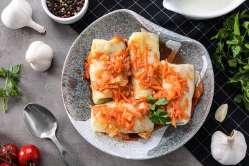 Delicious cabbage rolls served on grey table, flat lay