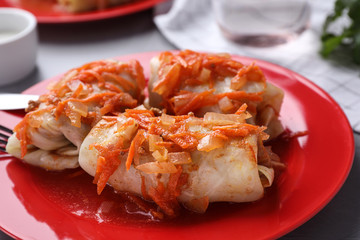 Delicious cabbage rolls served on red plate, closeup