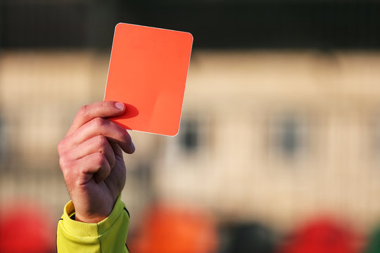 Football referee shows a red card.
