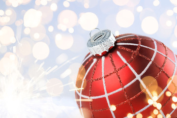 Red christmas ball on golden lights background.
