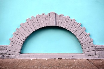 decorative element of gray stones on the turquoise wall of the building