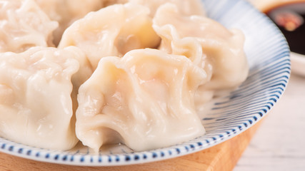 Fresh, delicious boiled pork gyoza dumplings, jiaozi on white background with soy sauce and chopsticks, close up, lifestyle. Homemade design concept.