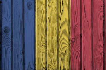 Romania flag depicted in bright paint colors on old wooden wall. Textured banner on rough background