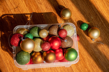 Christmas balls in a plastic transparent box on a floor ready to decorate a Christmas tree