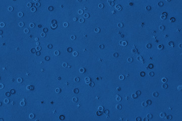 Monochrome metallic foil confetti background. Trendy classic blue colored circles and stars sparse on dark blue green colored paper. Simple holiday concept. Top view, flat lay. Color of the year 2020