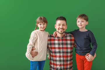 Happy family in winter clothes on color background