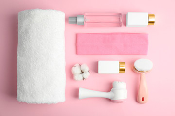 Flat lay composition with face cleansing brushes on pink background. Cosmetic tools
