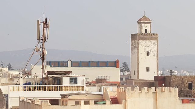 Stadtidylle mit Moschee und Bergen im Hintergrund