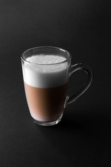 Cup of coffe with milk on a dark background. Cappuccino or Latte with milk in dark key with copy space. 