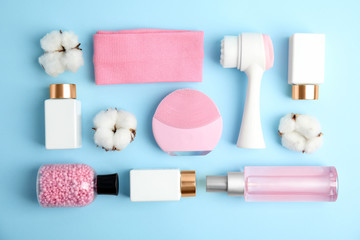 Flat lay composition with face cleansing brushes on light blue background. Cosmetic tools