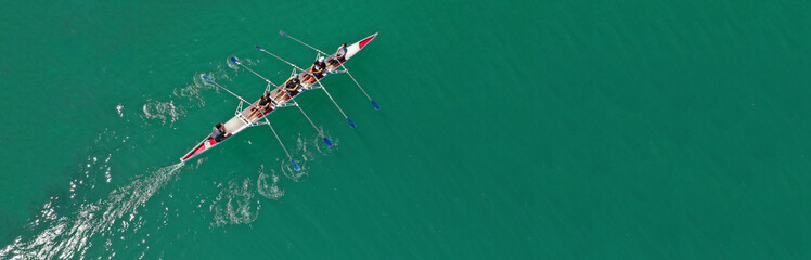 Aerial drone top panoramic view of sport canoe rowing synchronous athletes competing in tropical...