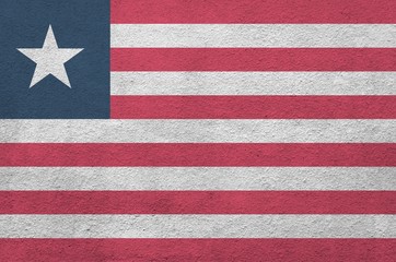 Liberia flag depicted in bright paint colors on old relief plastering wall. Textured banner on...