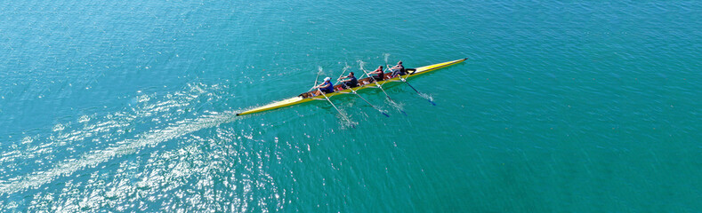 Aerial drone top panoramic view of sport canoe rowing synchronous athletes competing in tropical exotic lake - obrazy, fototapety, plakaty