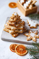 Homemade delicious gingerbread cookies put in a stack in the shape of fir tree. Family time, home bakery. Holiday atmopshere, festive mood. White background, close up