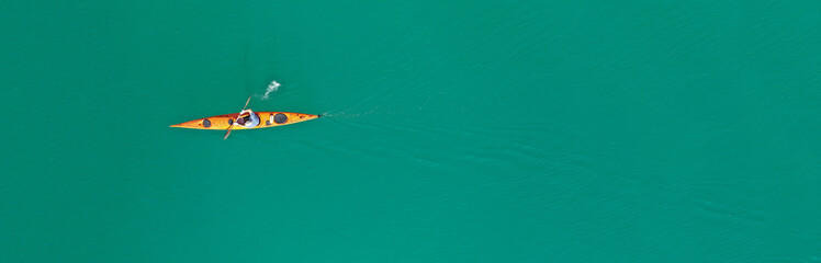 Aerial drone top panoramic view of sport canoe rowing synchronous athletes competing in tropical...