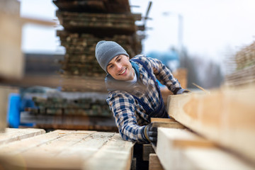 Young male worker in timber warehouse 