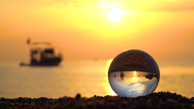 Beautiful sunrise over the Mediterranean Sea. Glass bowl with reflection of the sea. Sea yachts near the shore. 4K