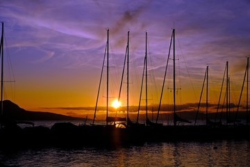 Gorgeous view of sunset on Lake Geneva with silhouette sailboats at the harbor, Vevey, Switzerland.