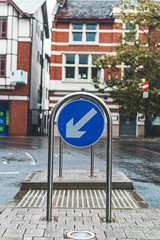 blue sign with white arrows on a street showing which h way to go. Copy space.