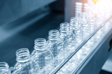 The PET bottles on the conveyor belt for filling process in the drinking water factory. The...