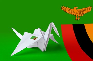 Zambia flag depicted on paper origami crane wing. Handmade arts concept