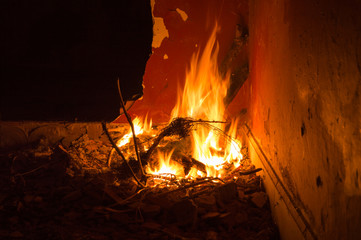 Fire of a bonfire in an abandoned place that gives an orange light.