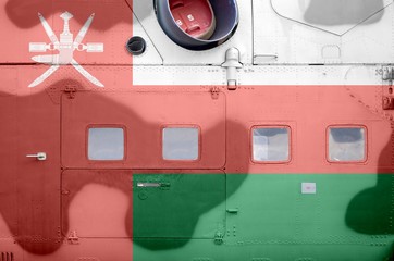 Oman flag depicted on side part of military armored helicopter closeup. Army forces aircraft...
