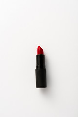 top view of black tube with red lipstick on white with copy space