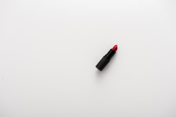 top view of tube with red lipstick on white