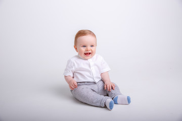 baby boy sitting on a white background. portrait of child smiling isolated on white background
