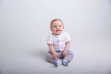 baby boy sitting on a white background. portrait of child smiling isolated on white background