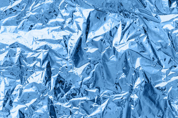 creased shiny metal foil sheet in trendy blue color. Background or backdrop