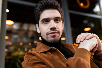 Obraz premium Portrait of young attractive casual man intently looking away while resting outdoor