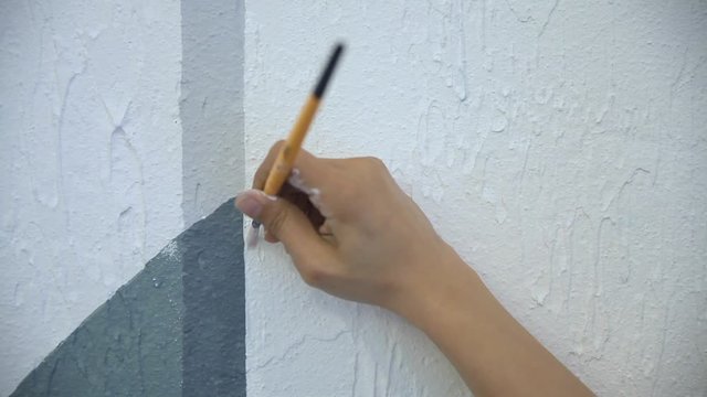 Female Hand Paiting The Wall With Brush White Paint