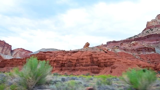 Scenic drive on road panning in slow motion Capitol Reef National Monument point of view of colorful stone red rock in Utah 
