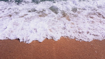 abstract background of sea waves, on golden sand, white sea foam, sunlight
