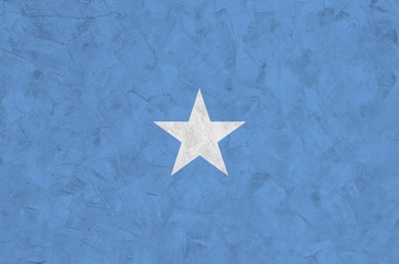 Somalia flag depicted in bright paint colors on old relief plastering wall. Textured banner on...