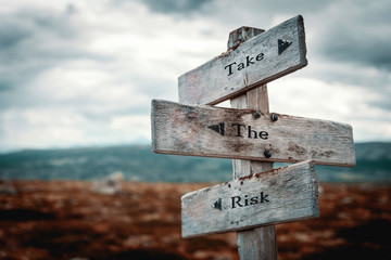 Take the risk  signpost outdoors in nature. Lifestyle and business concept.