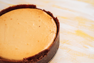 whole, freshly baked cheesecake on a neutral background