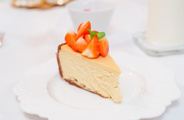 Fresh strawberry cheesecake on a ceramic plate on a white festive table